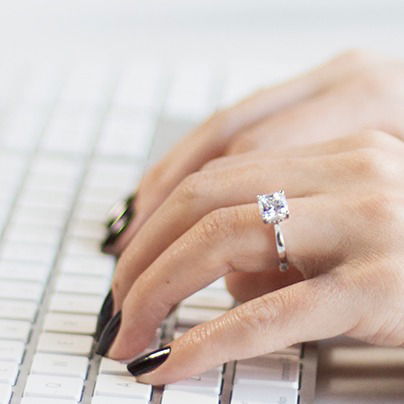 lab grown diamond engagement ring on a finger